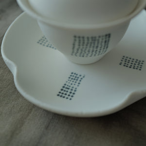 White ceramic gaiwan with lid on a matching saucer.