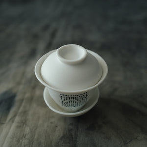 White ceramic gaiwan with a lid on a linen.