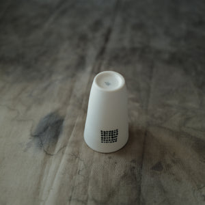 A white ceramic teacup on a linen background.